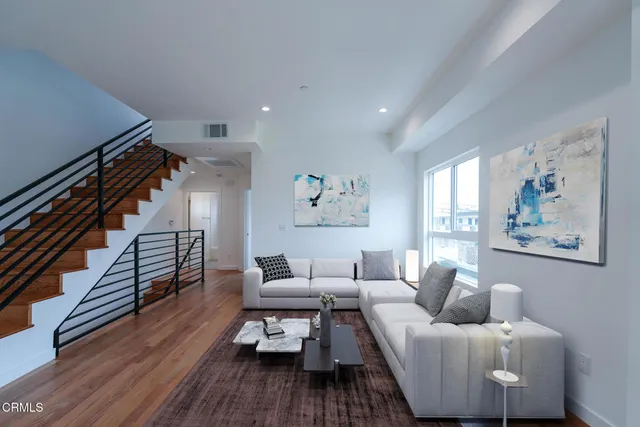 a living room with furniture and a wooden floor