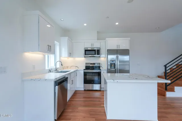 a large kitchen with stainless steel appliances granite countertop a stove a sink and a refrigerator