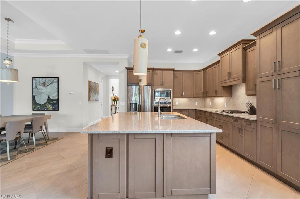 5769 Anegada Drive Naples, FL 34113 - Photo 11 of 45 a kitchen with kitchen island granite countertop a sink a counter top space stainless steel appliances and cabinets