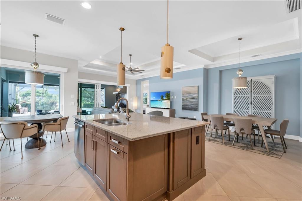 5769 Anegada Drive Naples, FL 34113 - Photo 12 of 45 a kitchen with kitchen island a sink a counter top space and living room view
