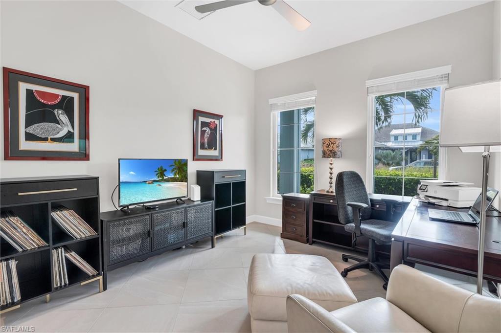 5769 Anegada Drive Naples, FL 34113 - Photo 15 of 45 a living room with furniture a flat screen tv and a fireplace