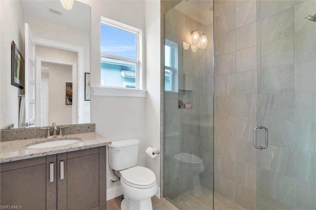 5769 Anegada Drive Naples, FL 34113 - Photo 17 of 45 a bathroom with a granite countertop sink toilet and shower