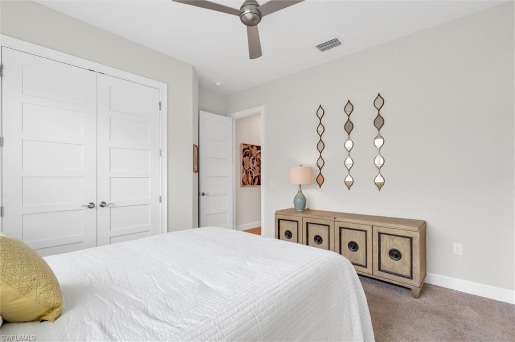 5769 Anegada Drive Naples, FL 34113 - Photo 19 of 45 a bedroom with a large bed and a chandelier