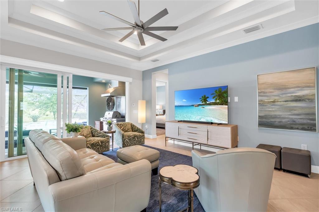 5769 Anegada Drive Naples, FL 34113 - Photo 6 of 45 a living room with furniture a large window and a flat screen tv