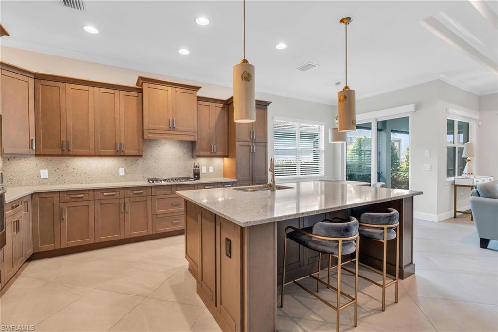 5769 Anegada Drive Naples, FL 34113 - Photo 9 of 45 a kitchen with a table chairs sink and cabinets