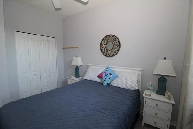 a bedroom with a bed and a lamp on the dresser