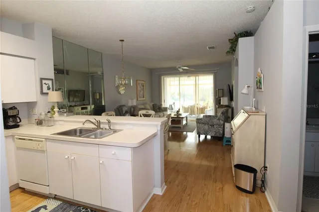a kitchen with sink refrigerator and cabinets