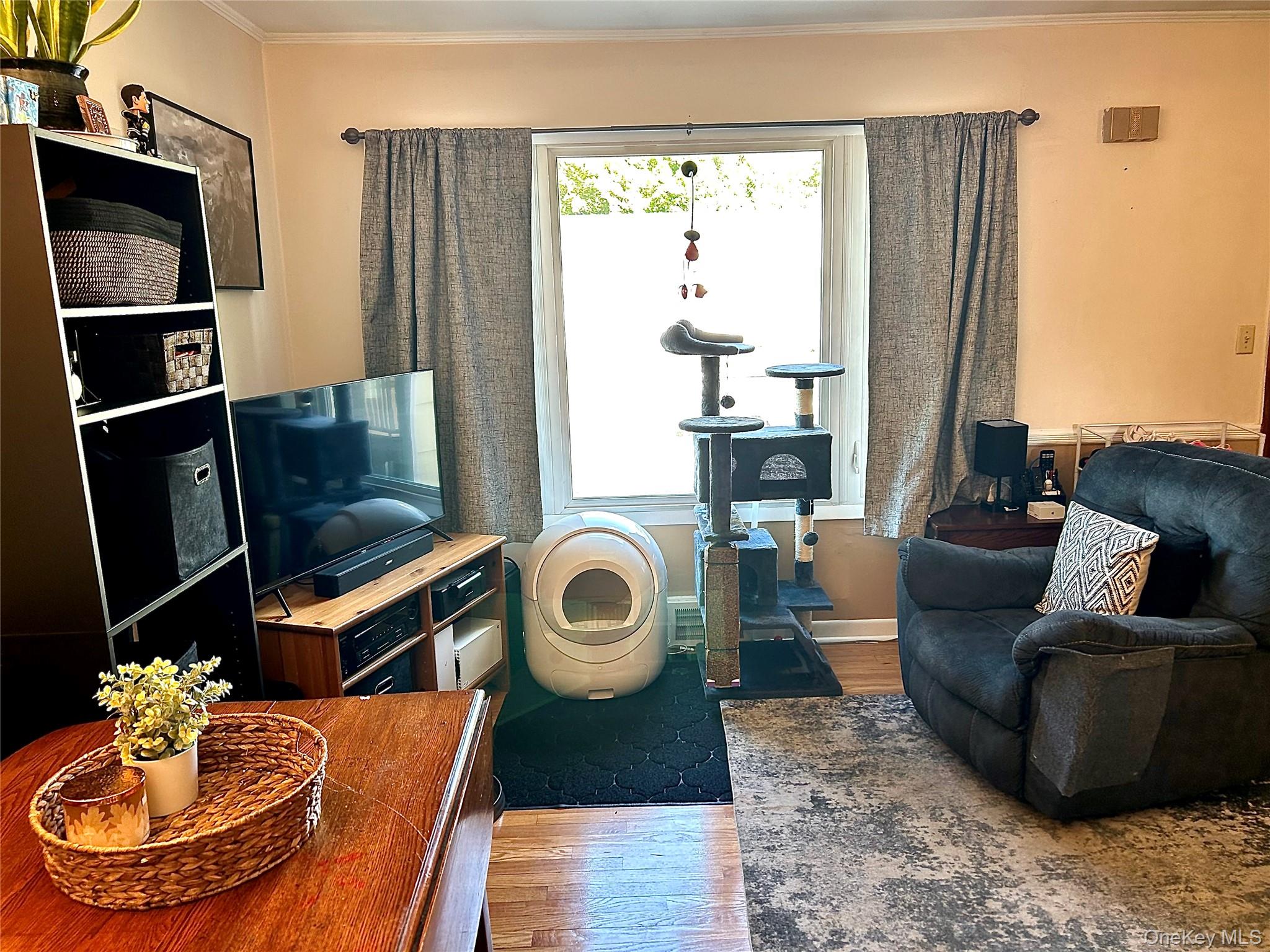 Living room featuring crown molding, hardwood  floors, and an office area
