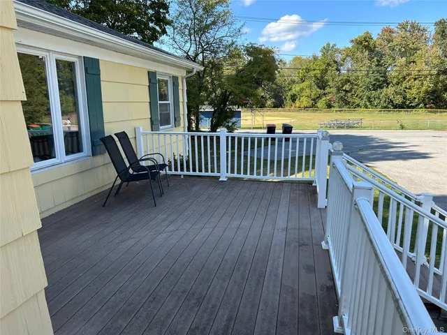 a view of a house with wooden deck and furniture
