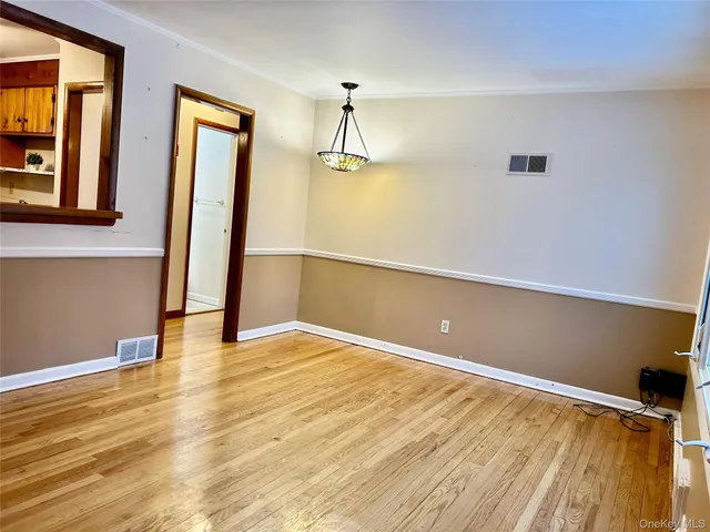 a view of a room with wooden floor and a window