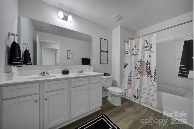 a bathroom with a double vanity sink toilet and shower
