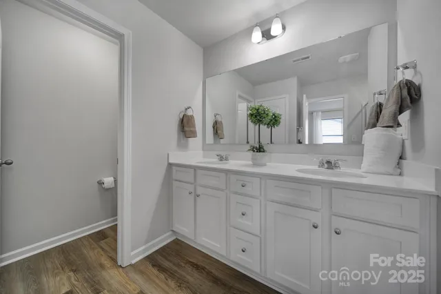 a bathroom with a double vanity sink and a mirror