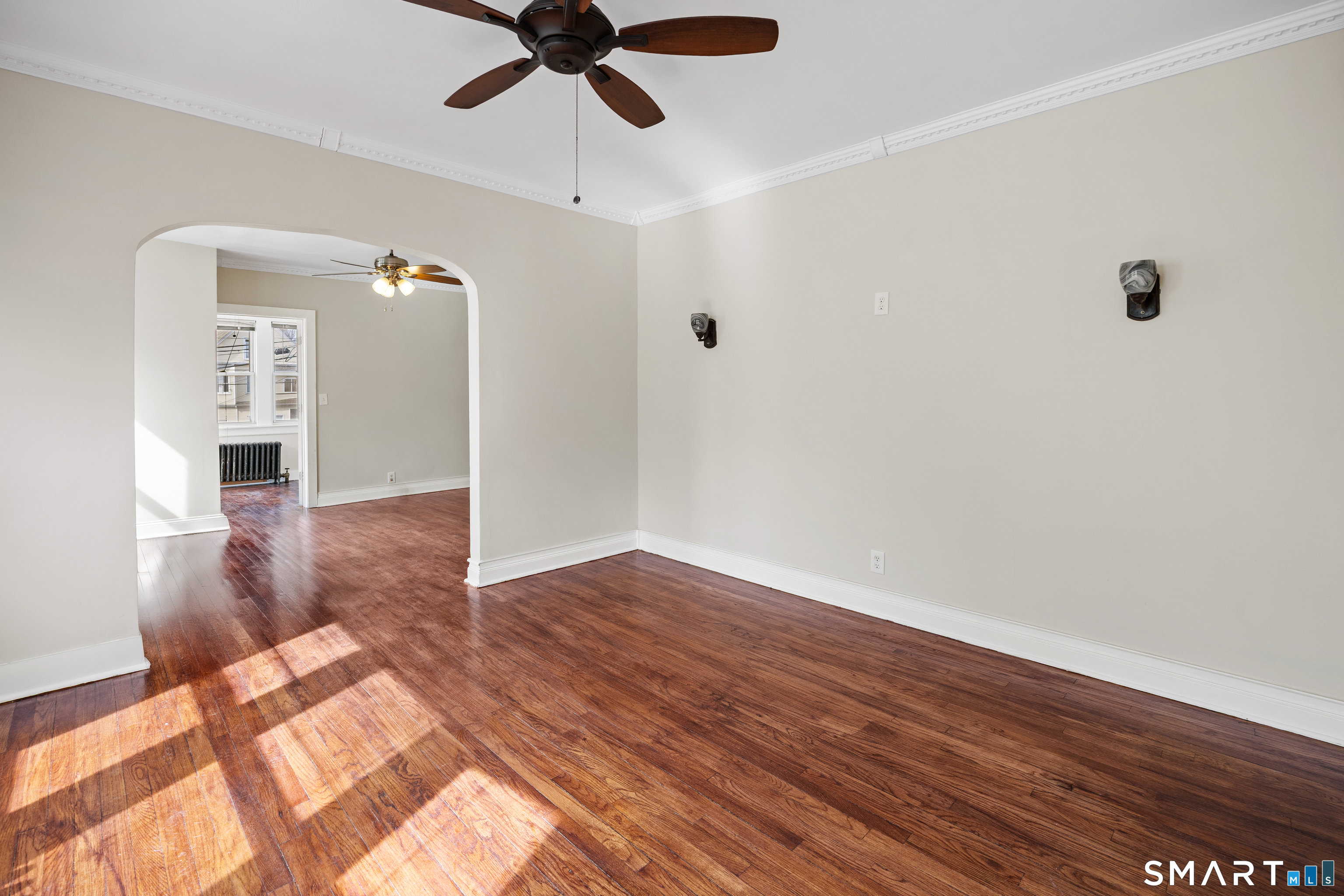 744 Park Street Bridgeport, CT 06608 - Photo 5 of 21 an empty room with wooden floor fan and windows