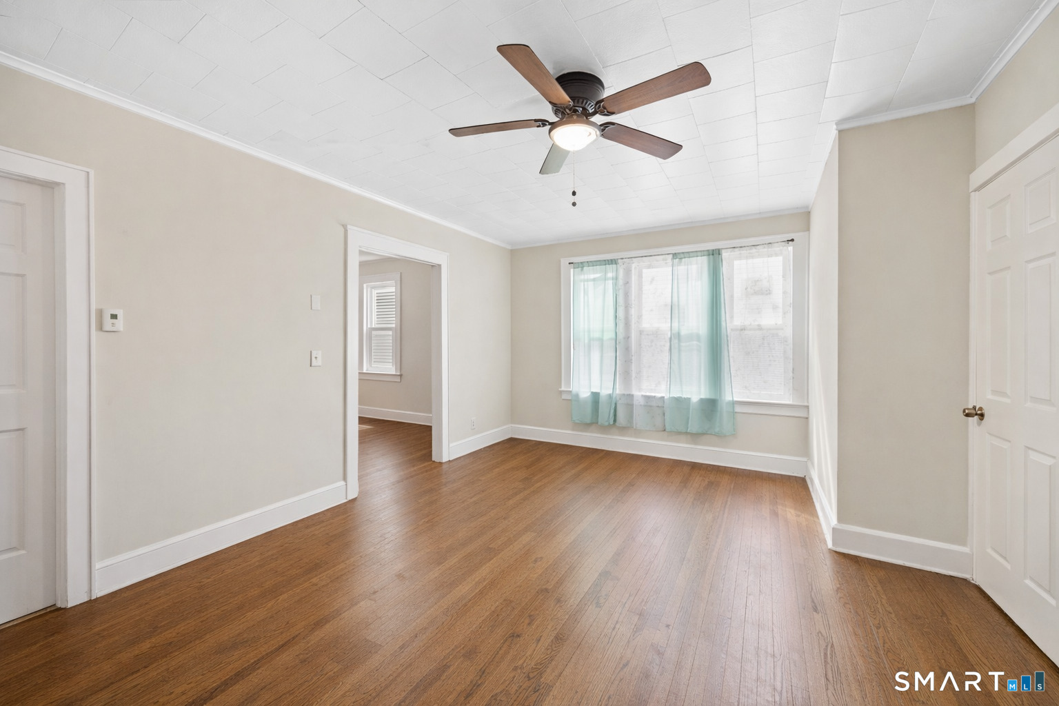 744 Park Street Bridgeport, CT 06608 - Photo 10 of 21 an empty room with wooden floor fan and windows
