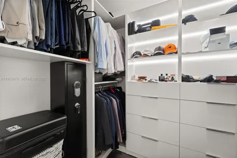 a view of walk in closet with clothes and shoes