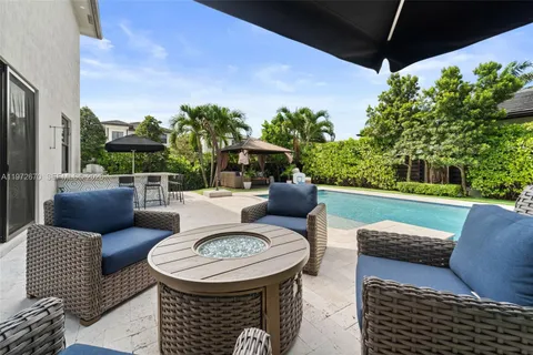 a view of a patio with couches table and chairs and potted plants