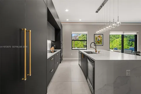 a large kitchen with a large window and stainless steel appliances