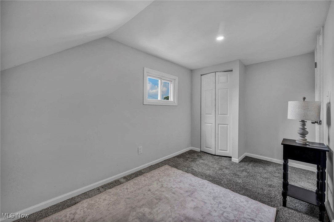 4649 Burleigh Road Cleveland, OH 44125 - Photo 27 of 37 Unfurnished bedroom with dark colored carpet, a closet, and vaulted ceiling