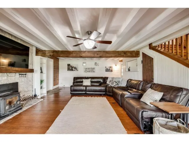 a view of a livingroom with wooden floor and stairs