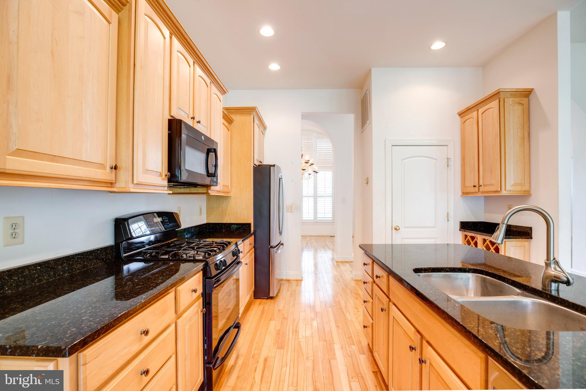 8277 Roxborough Loop Gainesville, VA 20155 - Photo 12 of 85 a kitchen with stainless steel appliances granite countertop a sink a stove cabinets counter space and a window