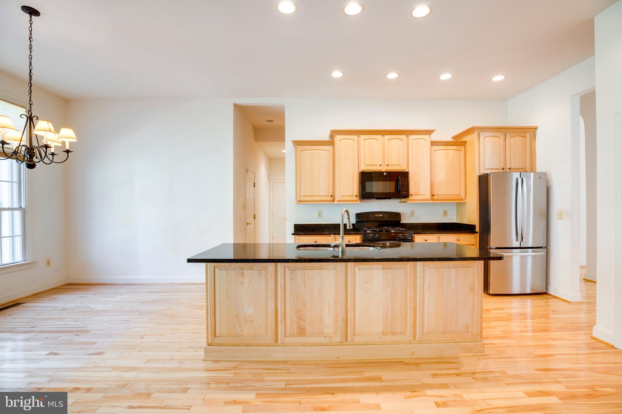 8277 Roxborough Loop Gainesville, VA 20155 - Photo 16 of 85 a kitchen with stainless steel appliances granite countertop a stove a sink and a refrigerator