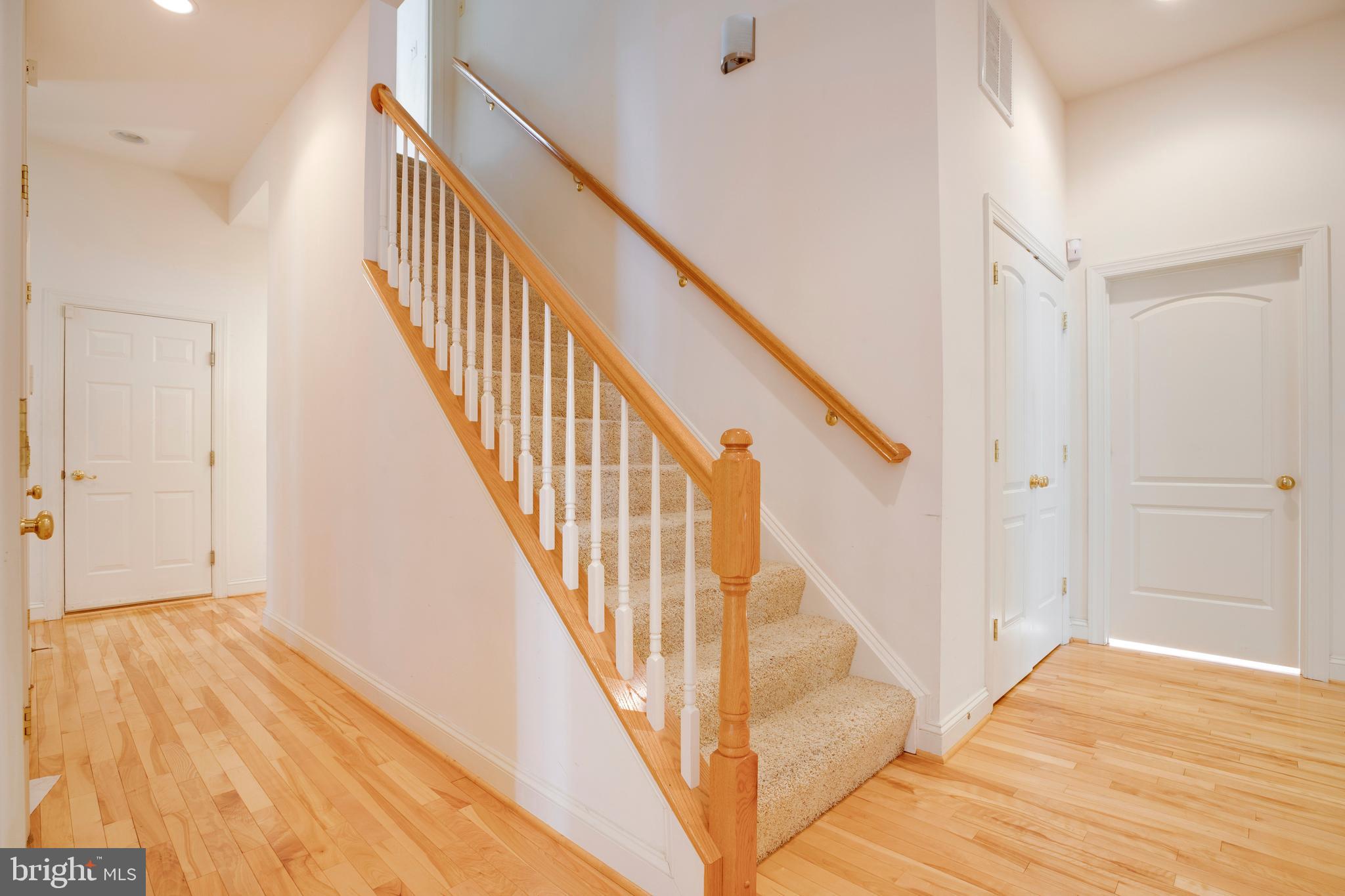 8277 Roxborough Loop Gainesville, VA 20155 - Photo 23 of 85 a view of a hallway with wooden floor and staircase