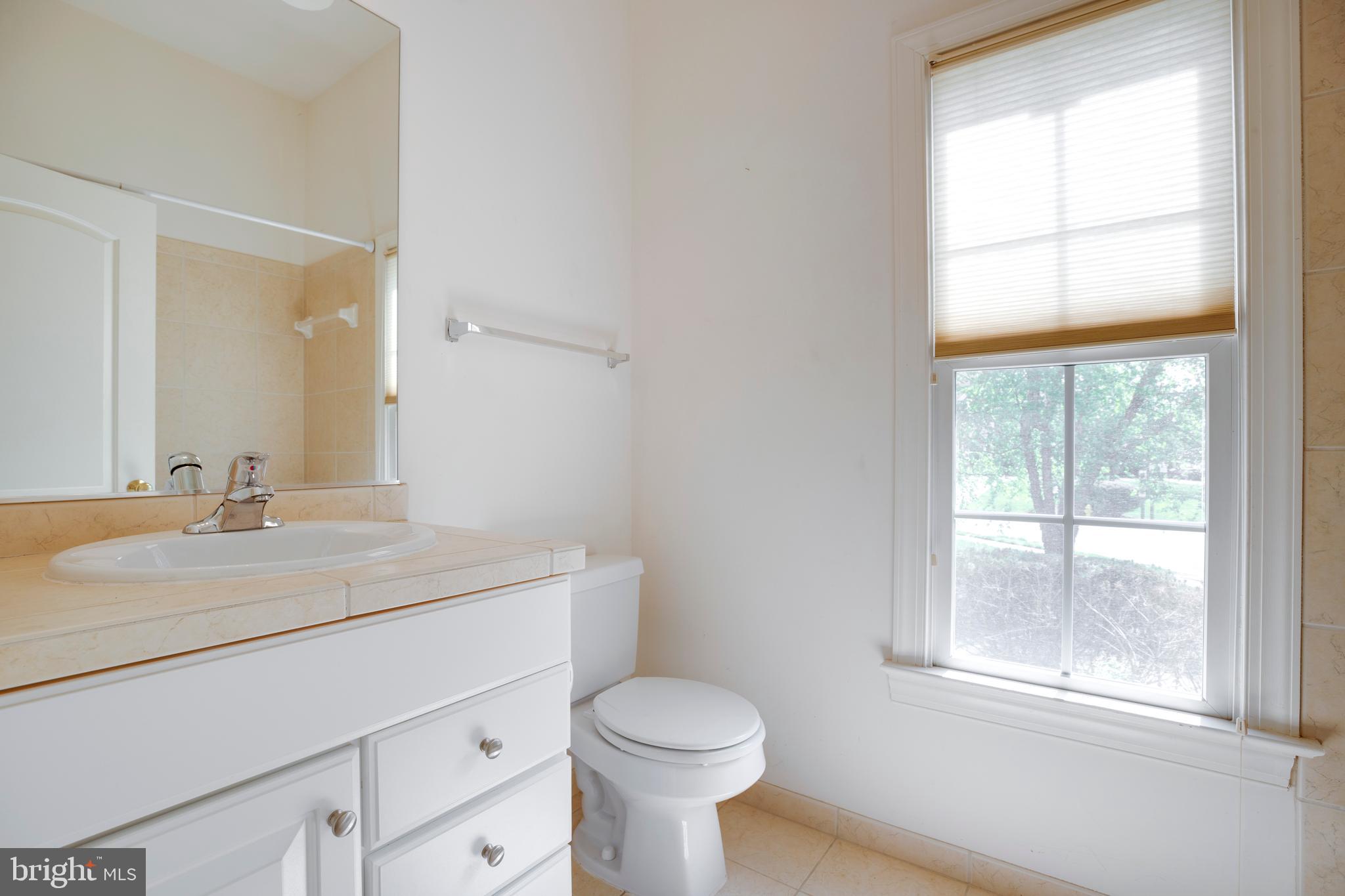 8277 Roxborough Loop Gainesville, VA 20155 - Photo 28 of 85 a bathroom with a toilet sink vanity and mirror