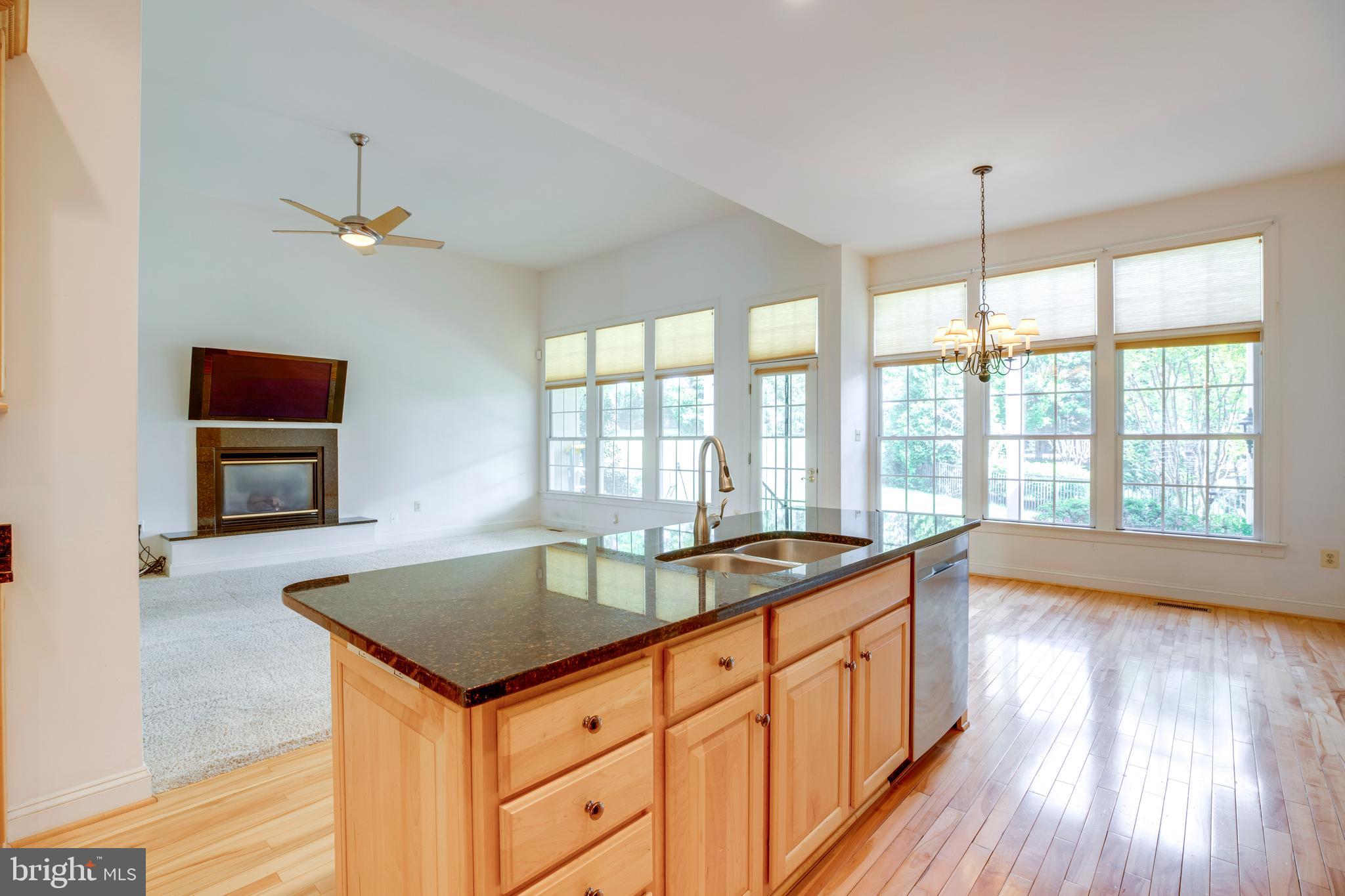 8277 Roxborough Loop Gainesville, VA 20155 - Photo 9 of 85 a kitchen with granite countertop a sink a counter top space and living room area