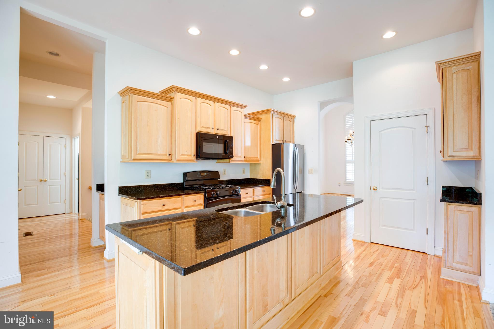 8277 Roxborough Loop Gainesville, VA 20155 - Photo 10 of 85 a kitchen with stainless steel appliances granite countertop a sink a stove and a refrigerator