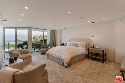 a large bedroom with a large bed and large window