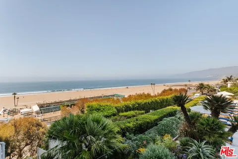 a living room with furniture and floor to ceiling windows