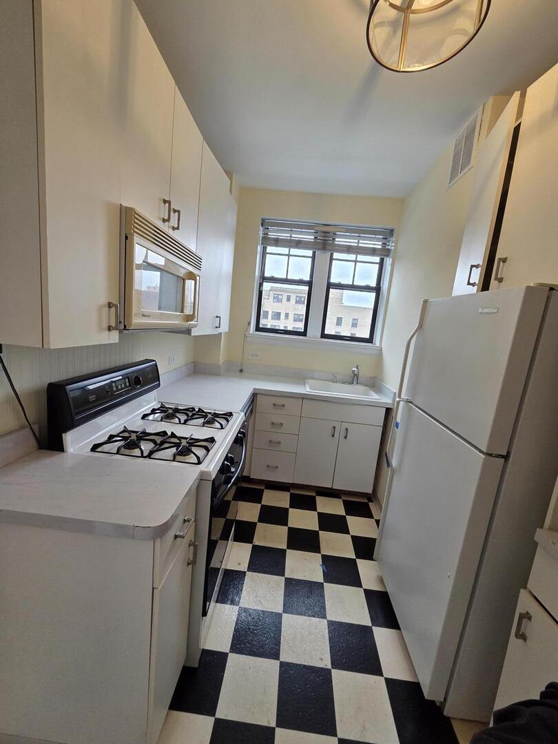 421 West Melrose Street, Unit 5D Chicago, IL 60657 - Photo 14 of 29 a kitchen with a stove a refrigerator and a black white checkered floor