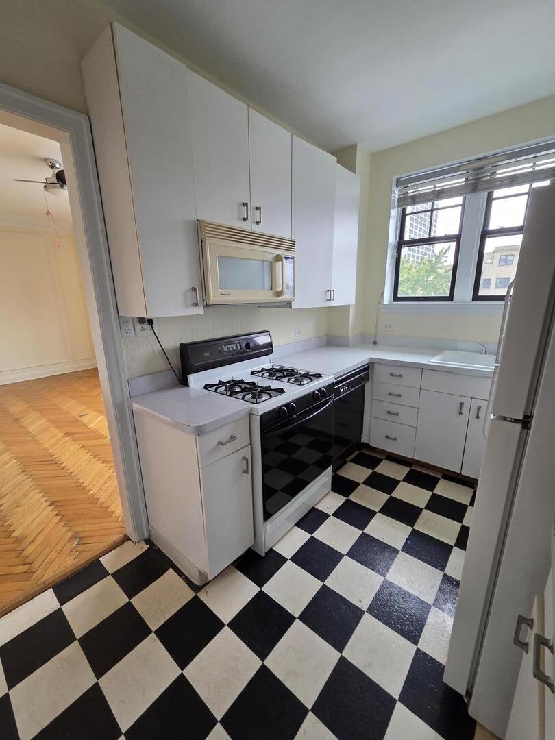421 West Melrose Street, Unit 5D Chicago, IL 60657 - Photo 16 of 29 a kitchen with a checkered floor and white cabinets