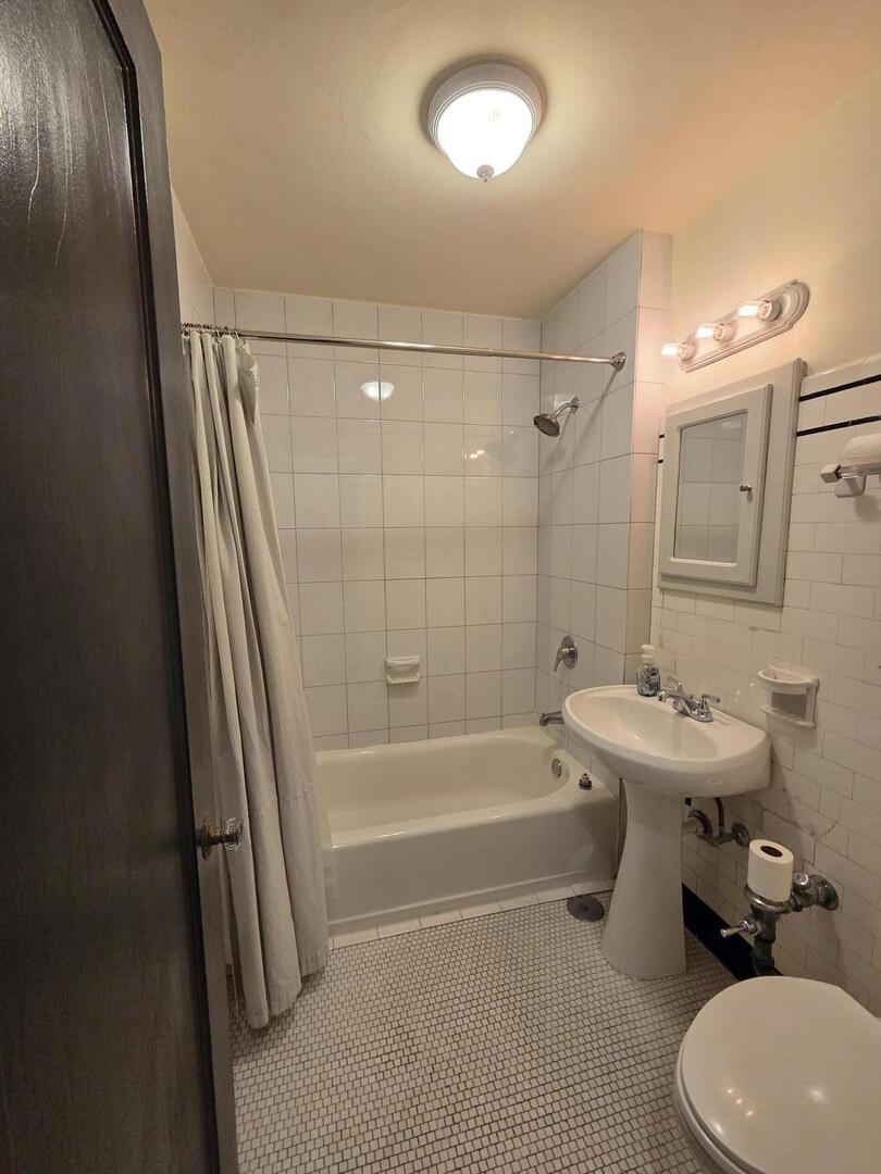 421 West Melrose Street, Unit 5D Chicago, IL 60657 - Photo 17 of 29 a bathroom with a sink a toilet a mirror and shower