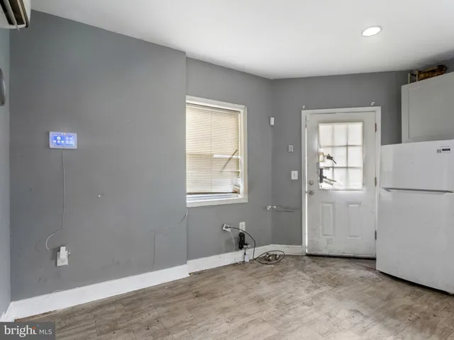a view of an empty room with closet and a bathroom