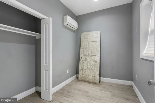 an empty room with wooden floor and a window