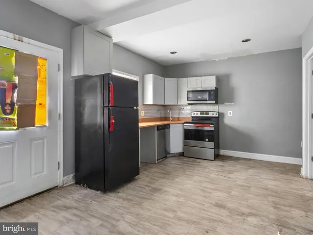 a kitchen with stainless steel appliances granite countertop a refrigerator and a stove