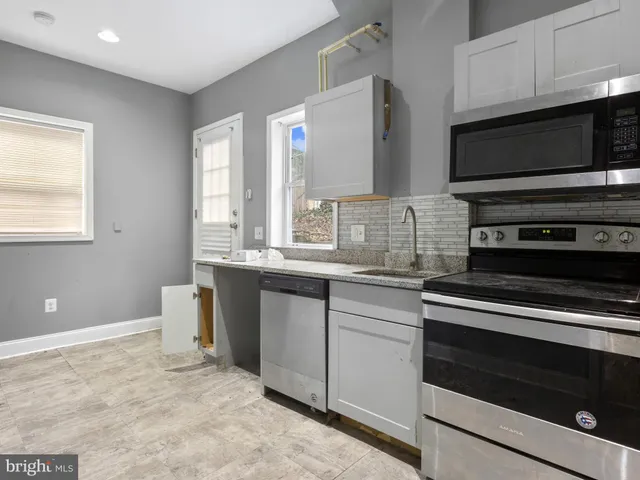 a kitchen with stainless steel appliances a stove microwave and sink
