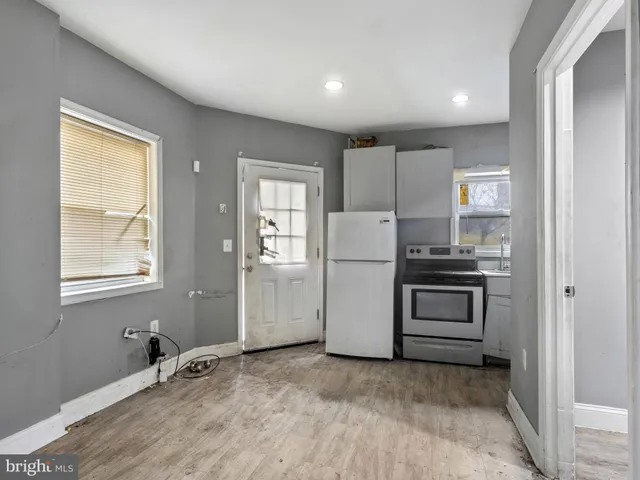 a view of a kitchen with refrigerator and window