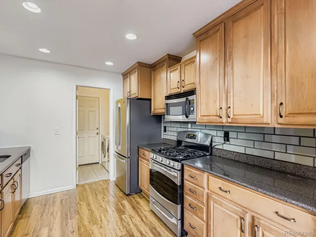 a kitchen with granite countertop a stove and a refrigerator