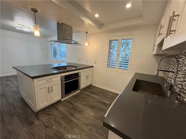 a kitchen with granite countertop a sink cabinets and stainless steel appliances