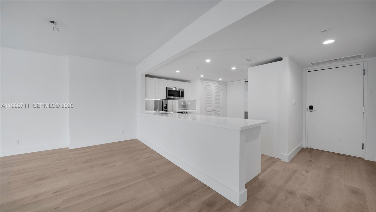 555 Northeast 34th Street, Unit 603 Miami, FL 33137 - Photo 12 of 28 a view of kitchen with center island and wooden floor