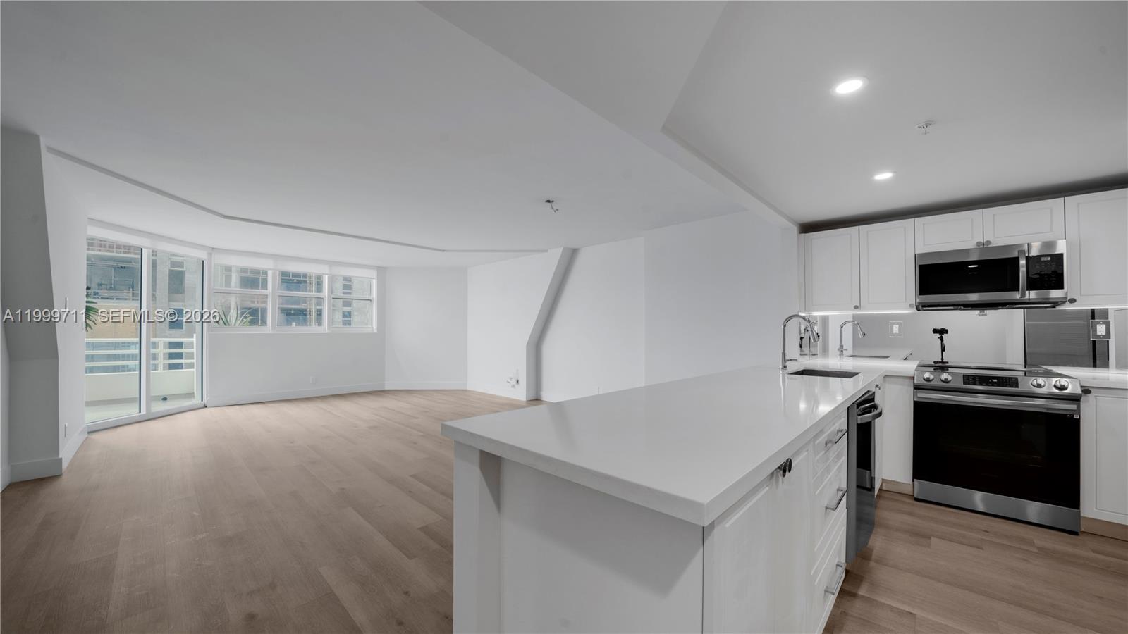 555 Northeast 34th Street, Unit 603 Miami, FL 33137 - Photo 7 of 28 a kitchen with a stove a sink and a microwave