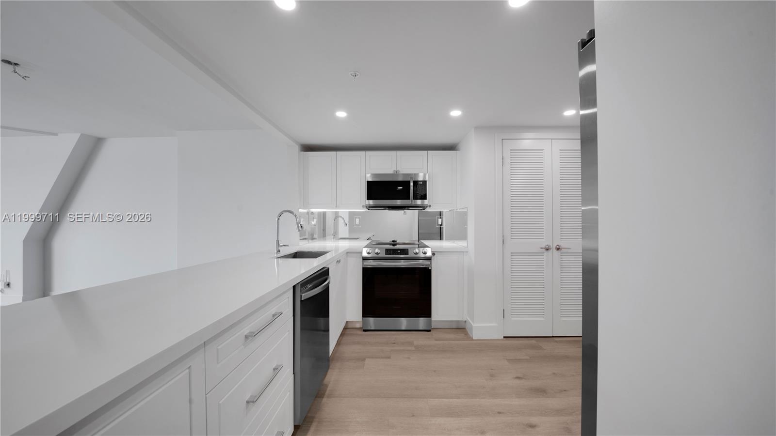 555 Northeast 34th Street, Unit 603 Miami, FL 33137 - Photo 8 of 28 a kitchen with stainless steel appliances granite countertop a stove and a sink