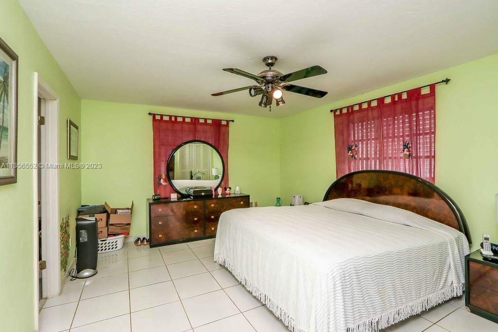 Redlands Homestead, FL 33031 - Photo 14 of 36 a bedroom with a bed and a chandelier