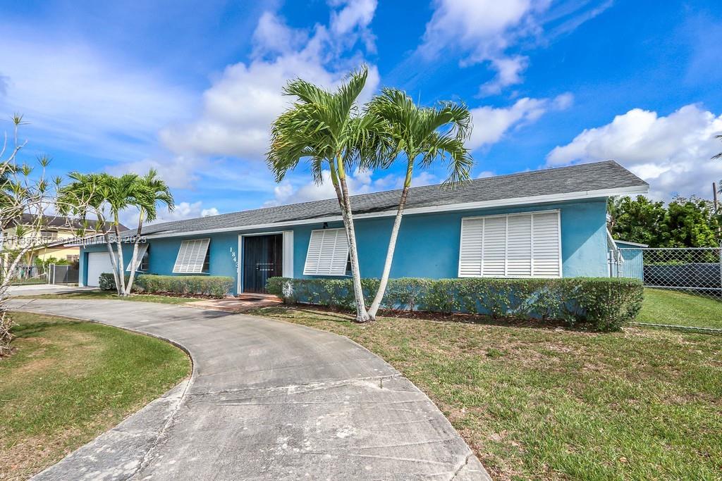 Redlands Homestead, FL 33031 - Photo 32 of 36 a front view of a house with a yard and potted plants
