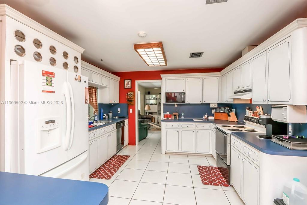Redlands Homestead, FL 33031 - Photo 10 of 36 a kitchen with a refrigerator a stove top oven a sink and cabinets