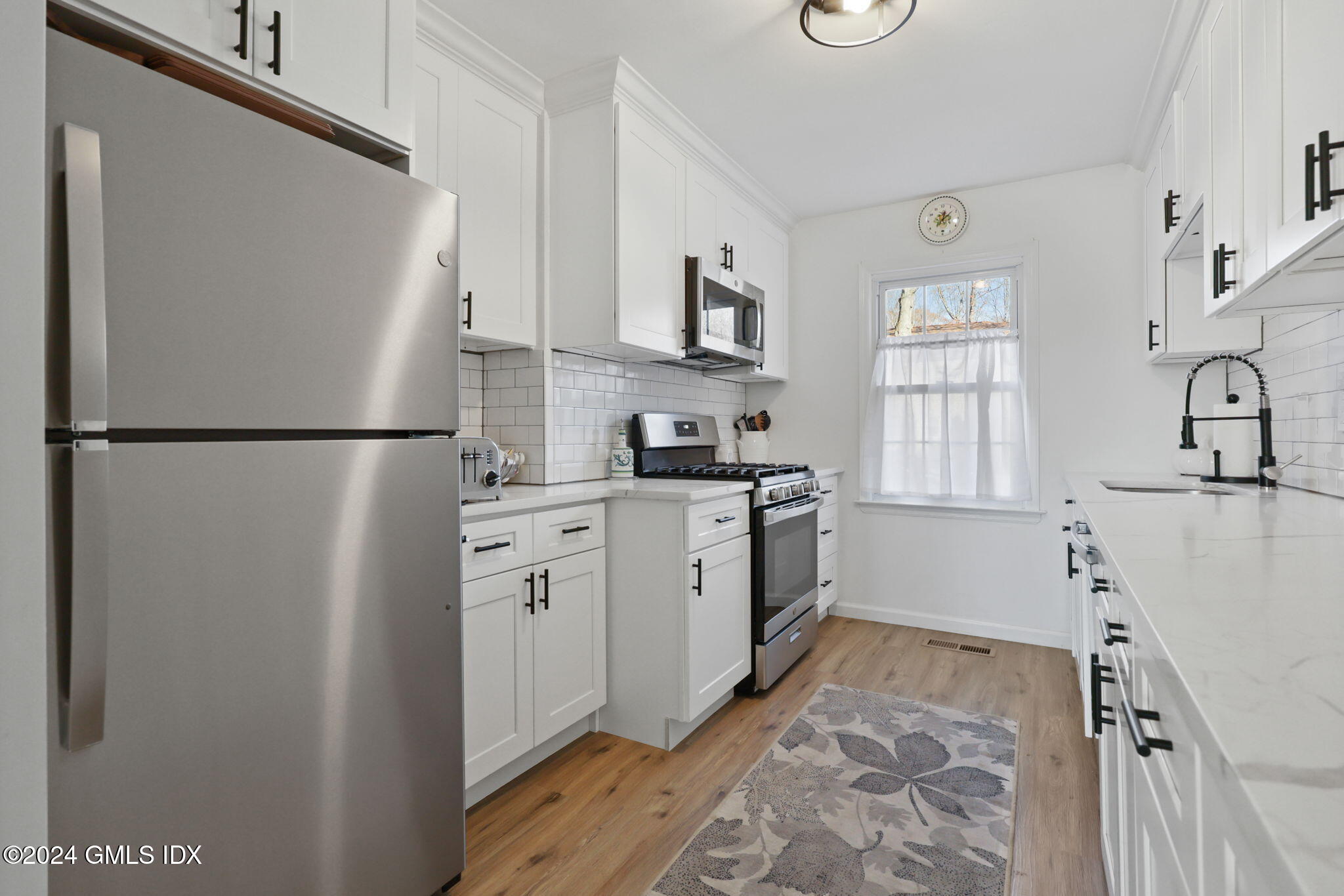 a kitchen with a refrigerator a stove a microwave and cabinets