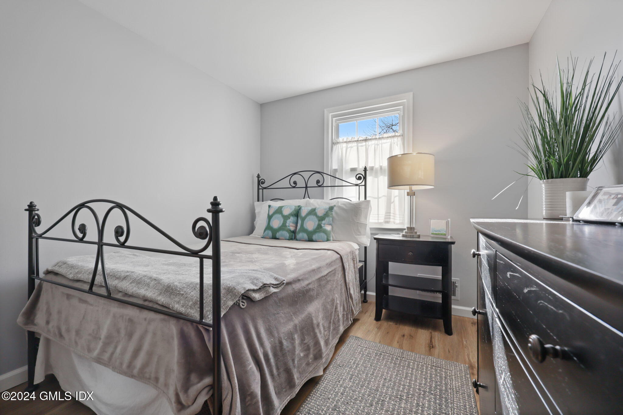 98 Valley Road, Unit 6 Cos Cob, CT 06807 - Photo 7 of 16 a bedroom with a bed and a flat tv screen on the dresser