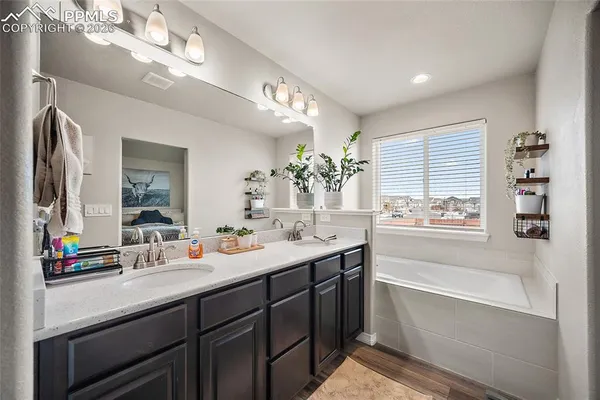 a bathroom with a tub sink and mirror